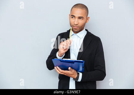 Nachdenklich afroamerikanischen jungen Mann schreiben in Zwischenablage Stockfoto