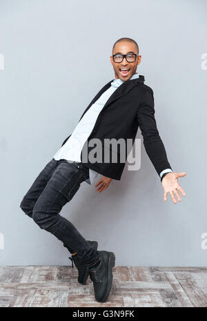 Glücklich afrikanischen jungen Mann in Gläser tanzen und Lächeln Stockfoto