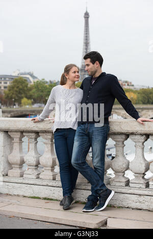 Junges Paar, der Mann und die Frau auf der Brücke stehen am Ufer der Seine, Paris, Frankreich, vor Eiffelturm Stockfoto