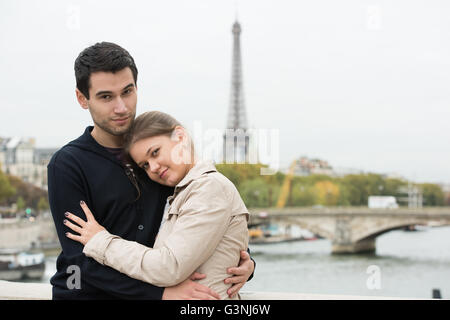 junges Paar Mann und Frau auf der Brücke am Seineufer, Paris, Frankreich, vor Eiffelturm, umarmen Stockfoto