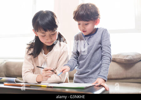 Glücklich Geschwister zu Hause gemeinsam studieren Stockfoto