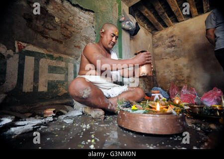 Kathmandu, Nepal. 21. April 2016. RAM-Duwal, 29 Jahre alt, religiöses Ritual Puja "SARADA" ihrer Mutter Betii Duwal, 68 Jahre alt in seinem zerstörten Haus, die während der letztjährigen Erdbeben in Tahamala, Bhaktapur, Nepal Untergang durchführen. Die meisten der alten wurden Häuser in Bhaktapur schlecht vom letztjährigen Erdbeben mit einer Magnitude von 7,8 Tötung über 8.000 Menschen in Nepal und Tausende von zerstört verletzt, wodurch Hunderte von Menschen in vielen Bezirken des Landes Obdachlose mit ganze Dörfer wurden. © Narayan Maharjan/Pacific Press/Alamy Live-Nachrichten Stockfoto