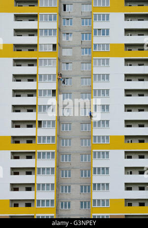 Industriekletterer Putz und Farbe der Wand entsteht eine neue mehrstöckige Wohngebäude Stockfoto