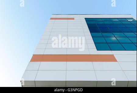 Teil der Wand mit Fenstern eines modernen Gebäudes, geschmückt mit farbigen rechteckigen Metallplatten. Stockfoto