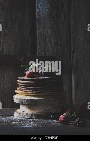 Frühstück im Holz: Schokolade Pfannkuchen mit Erdbeeren, Brombeeren und Puderzucker Stockfoto