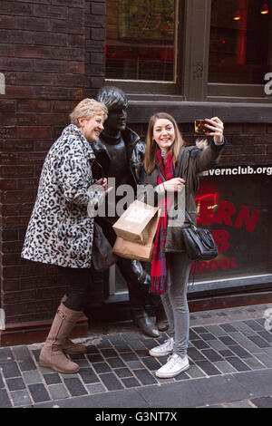 Merseyside, Liverpool, Mathew Street, Touristen nehmen Selfie mit John Lennon-Statue von Arthur Dooley Stockfoto