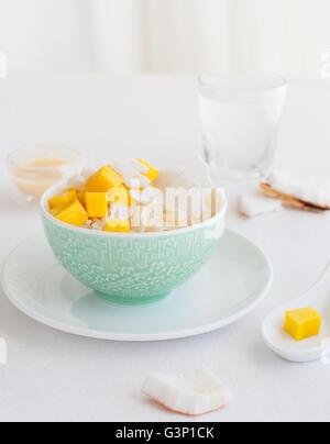 Milchreis mit Mango und Kokosnuss Wasser in Schüssel Stockfoto