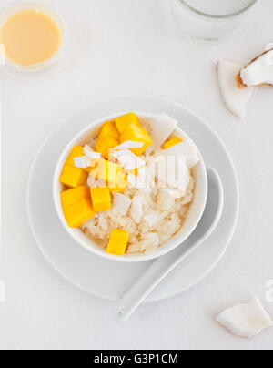 Milchreis mit Mango und Kokosnuss Wasser in Schüssel Stockfoto