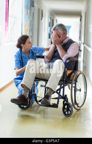 Ärztin, tröstende senior woman im Korridor Stockfoto