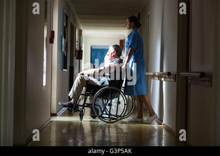 Patienten im Rollstuhl schieben durch eine Krankenschwester Stockfoto