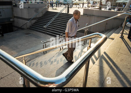 Ein Mann mittleren Alters geht die Treppe am Eingang zur u-Bahn in Istanbul, Türkei Stockfoto