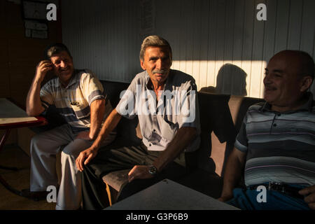 Treiber in einem Busdepot entspannen Sie sich in der Morgensonne vor Beginn ihres Arbeitstages in Safranbolu, Türkei Stockfoto