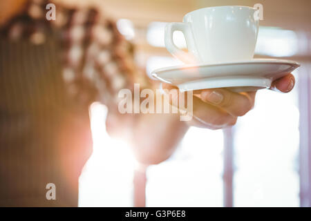 Kellner, die Übergabe eines Kaffees Stockfoto