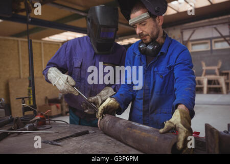 Männer arbeiten gemeinsam an einem Metallarbeiten Stockfoto