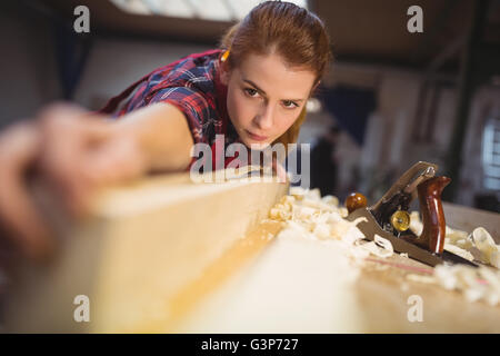 Frau Zimmermann Messlänge von Holzbrett Stockfoto