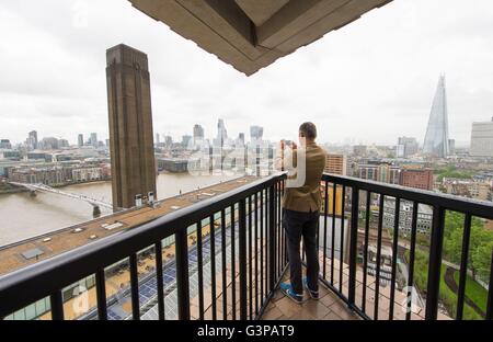 Ein Besucher übernimmt ein Bild von der Aussicht Zentrum von London aus die Galerie in der neuen Schalter Wohnhauserweiterung der Tate Modern in Southwark, London. Stockfoto