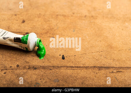 Tube mit grüner Acrylfarbe auf des Künstlers Tisch. Stockfoto