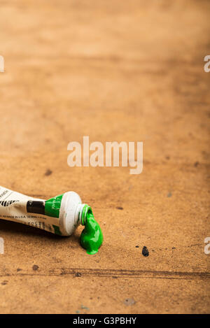 Tube mit grüner Acrylfarbe auf des Künstlers Tisch. Stockfoto