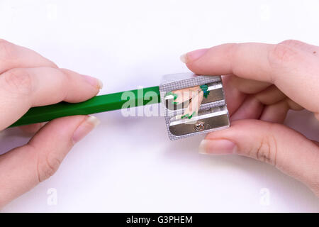 Hände, die einen grünen Stift schärfen Stockfoto