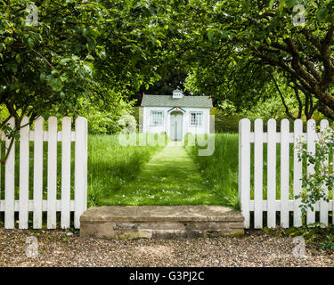 Weiße Kinder Spielhaus zum Jahresende einen Rasen Weg, weißen Lattenzaun Eingang. Stockfoto