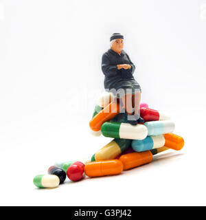 Frau, Miniatur Figur sitzt auf Arzneimittel Stockfoto