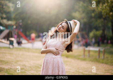 Junge Frau in rosa Kleid mit Hut Stockfoto