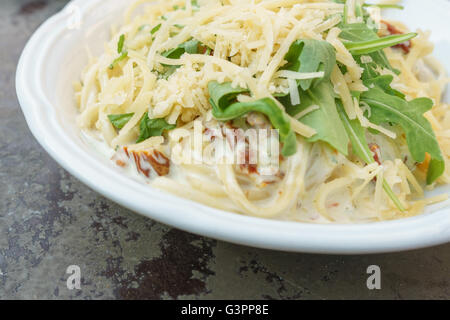 Cremige Nudeln mit getrockneten Tomaten, Käse, Rucola und frischem Basilikum-pesto Stockfoto