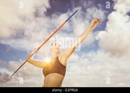 Zusammengesetztes Bild der niedrigen Winkel Ansicht der Sportlerin übt Speerwerfen Stockfoto