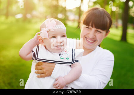 Schönen Lifestyle Sommer Foto Mutter und baby Mädchen Spaziergänge im Park Stockfoto