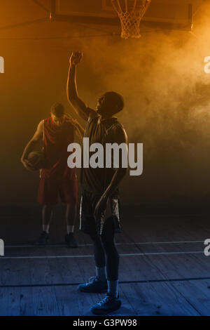 Seine Arme hob siegreich Basketballspieler Stockfoto