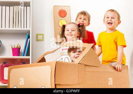 Glückliche kleine Reisende Karton Auto fahren Stockfoto