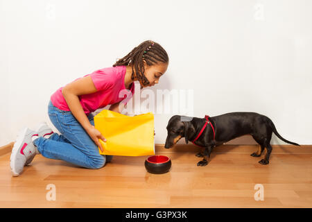 Schwarze Mädchen Essen auf Teller Hund Stockfoto