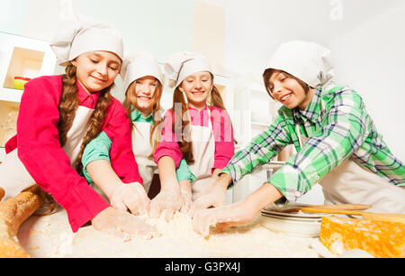 Vier Freunde kneten Bäckerei Teig in der Küche Stockfoto