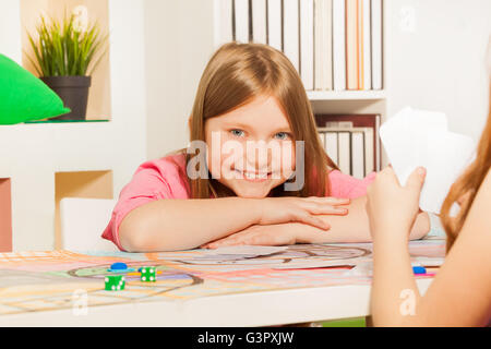 Glückliches Mädchen-Spielkarten mit ihrer Gegnerin Stockfoto