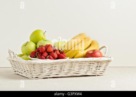 Früchte und Beeren auf einem weißen geflochtenen Tablett. Selektiven Fokus. Stockfoto