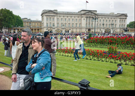 Gruppen von Touristen Spaß fotografieren sich mit Buckingham Palace in den Boden zurück. Stockfoto