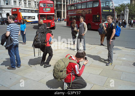 Eine Gruppe von Touristen fotografieren mit Blick auf die Houses of Parliament. Stockfoto