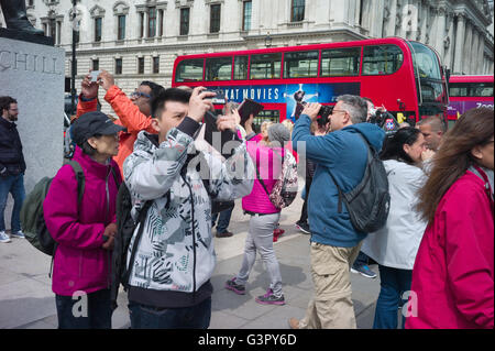 Eine große Gruppe von Touristen in Parliament Square fotografieren um Winston Churchills Statue. Stockfoto