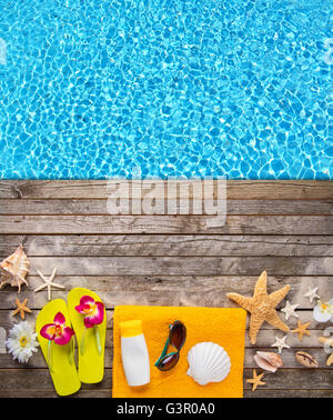 Strand-Accessoires auf hölzernen Hintergrund platziert auf Schwimmbad. Exemplar für text Stockfoto