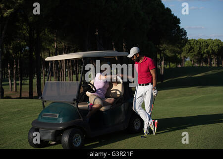 paar im Buggy Warenkorb auf Golfplatz Stockfoto
