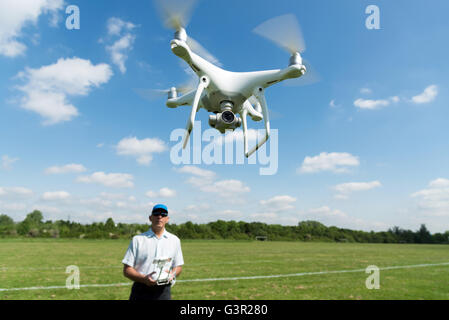 Man DJI Phantom 4 Quadrocopter Drohne im Park, England, UK Stockfoto