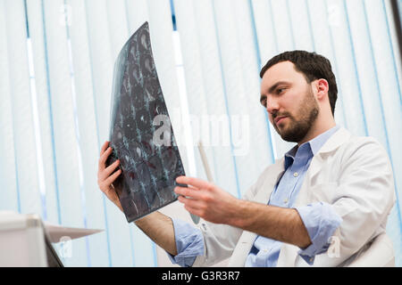 Junge männliche Arzt lesen und Überprüfung einen MRI Gehirn-scan Stockfoto