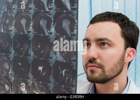 Arztpraxis - Porträt des mittleren Alters männlichen Arzt Blick auf Computer-Tomographen Scan. Stockfoto