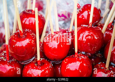 Sweet glasiert rote Toffee Liebesäpfel auf Sticks für den Verkauf auf dem Wochenmarkt oder Jahrmarkt. Stockfoto