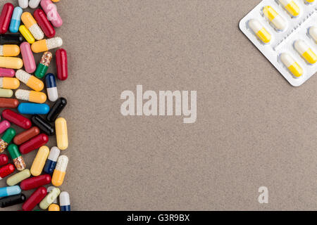 Verschiedene bunte Kapseln und Pillen auf braunen Kraftpapier Stockfoto