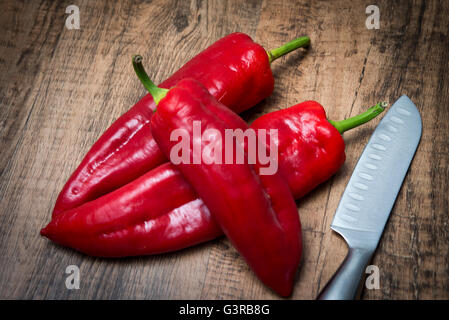 rote Spitzen Paprika und Messer auf Schneidebrett Stockfoto