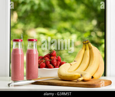 Erdbeer Smoothie in Glasflasche auf grünem Hintergrund. Selektiven Fokus. Stockfoto