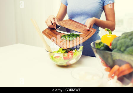 Nahaufnahme von Frau mit gehackten Zwiebeln Kochen Salat Stockfoto