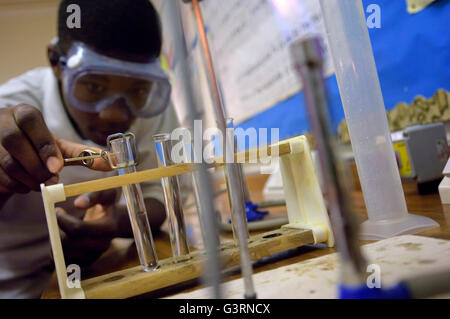 Männliche Schüler ein Reagenzglas während Wissenschaft Lektion Experiment zu halten. England. UK Stockfoto
