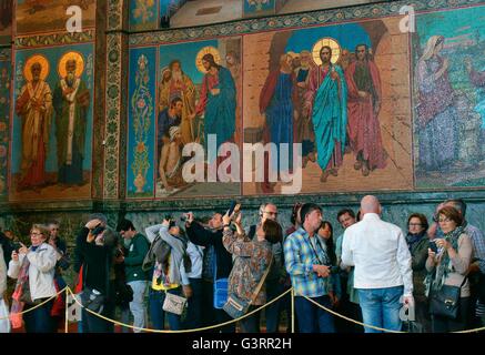 Sankt Petersburg in Russland. Russisch-orthodoxe Kirche des Retters auf Blut. Touristen sehen innen Mosaike der Heiligen Stockfoto